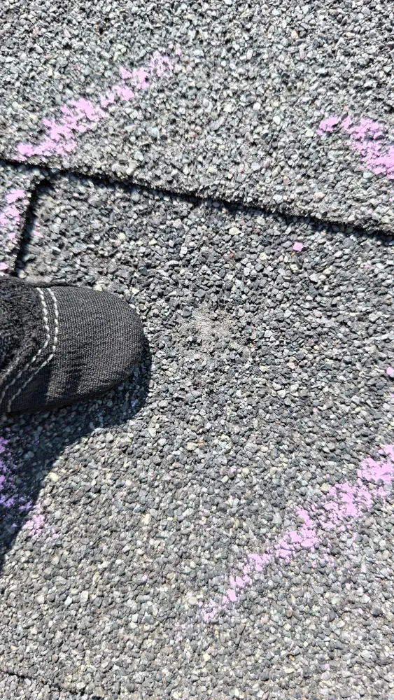 Close up of hail impact point with a thumb for comparison