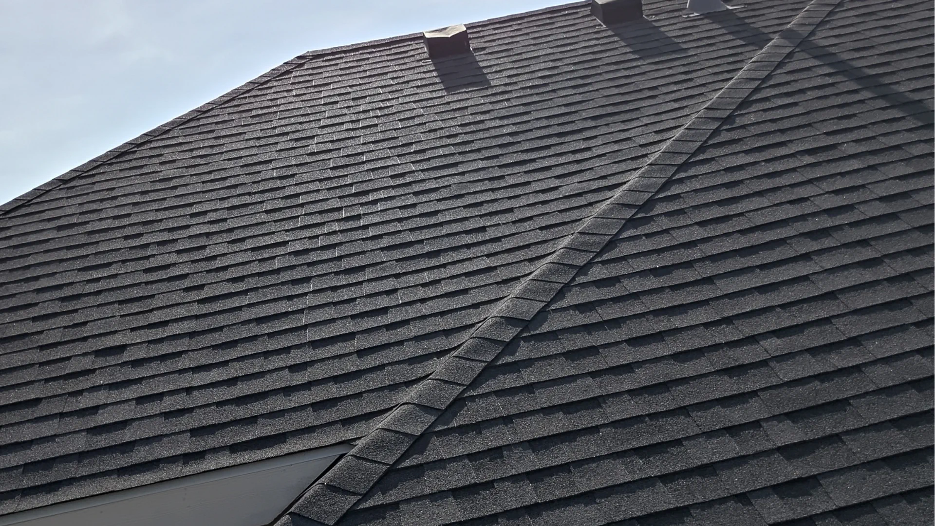 Close up of damaged manufacturer grade architectural shingles