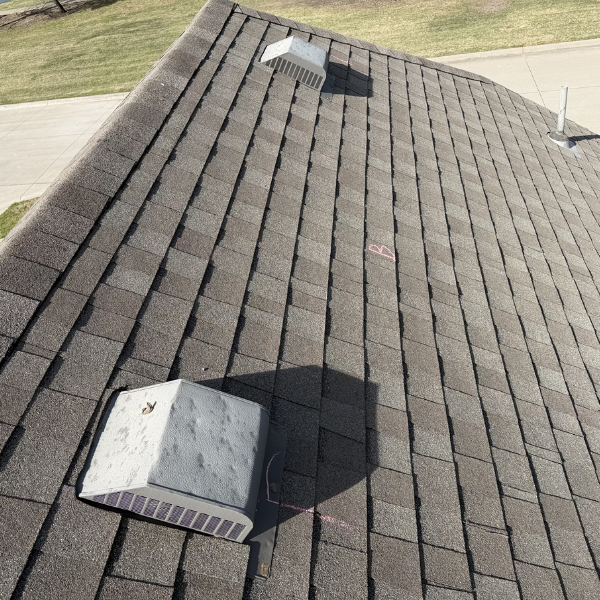 view of extreme hail damaged to two metal box vent on a roof with architectural shingles