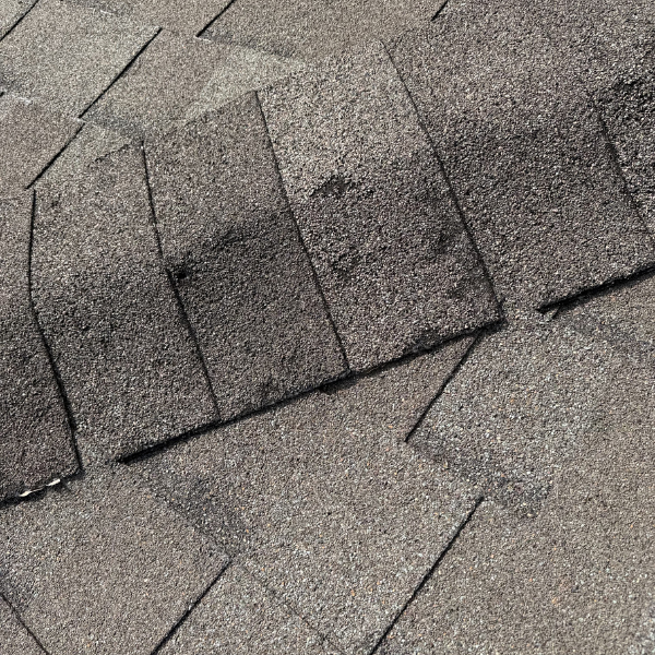 Close up of hail and wind damage to a roof ridge